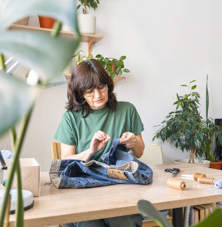 Adult woman mending blue denim pants